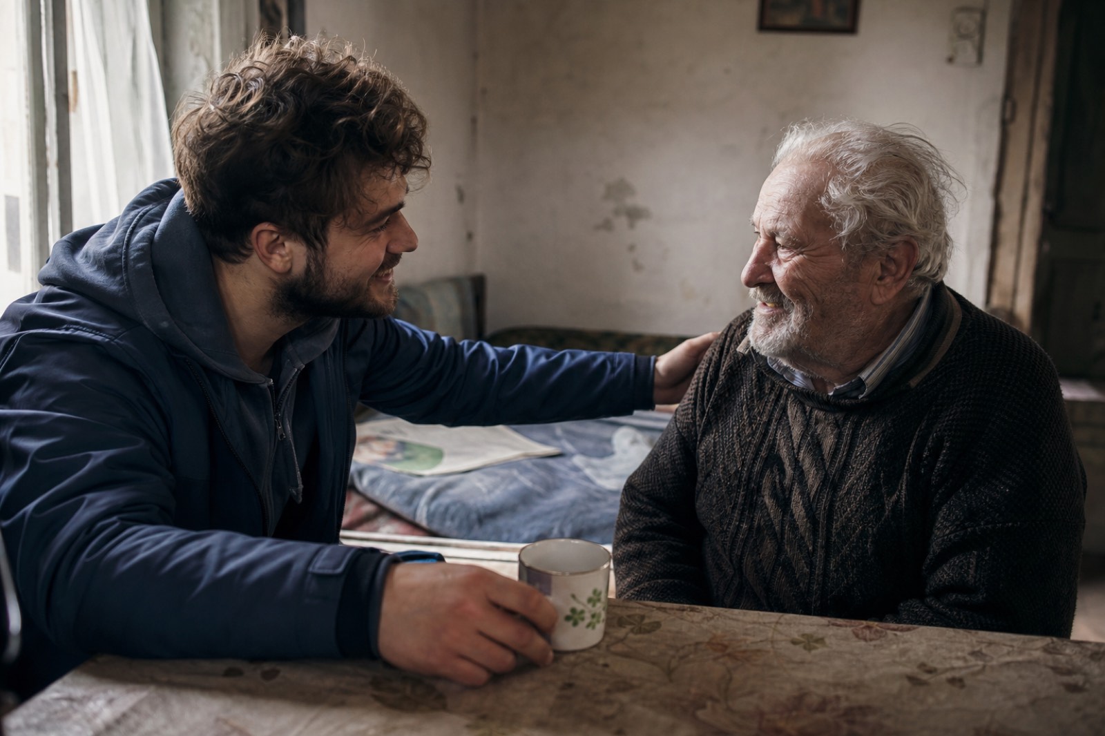 A young volunteer sharing a warm moment with an isolated elderly man